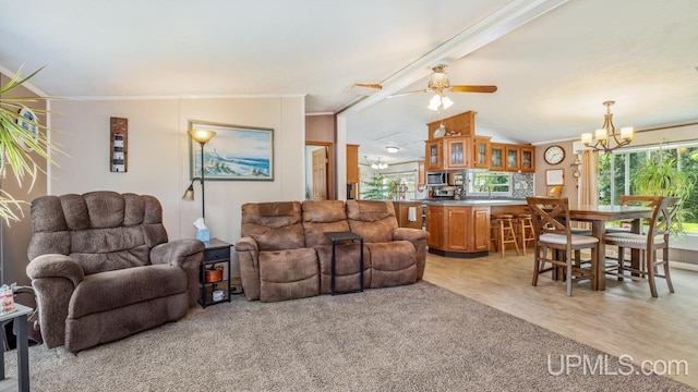11745 T Rd, Rapid River, MI 49878 - living room featuring a chandelier, crown molding, light wood-style floors, vaulted ceiling, and a ceiling fan