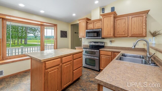 W5716 Warner Ln, Norway, MI 49870 - kitchen featuring stainless steel appliances, a sink, light countertops, a center island, and lofted ceiling