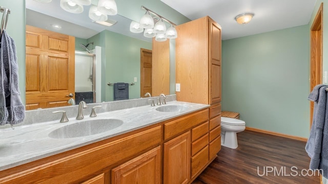 W5716 Warner Ln, Norway, MI 49870 - full bath with toilet, double vanity, an enclosed shower, wood finished floors, and baseboards