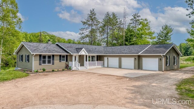 W5716 Warner Ln, Norway, MI 49870 - ranch-style home with driveway, covered porch, a garage, and a chimney