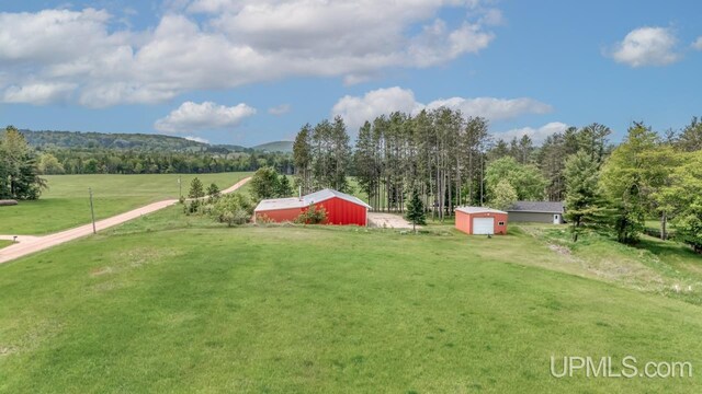 W5716 Warner Ln, Norway, MI 49870 - view of green lawn featuring an outbuilding, an outdoor structure, a view of rural / pastoral area, and a detached garage