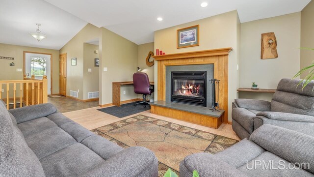W5716 Warner Ln, Norway, MI 49870 - living room featuring wood finished floors, a glass covered fireplace, baseboards, recessed lighting, and lofted ceiling