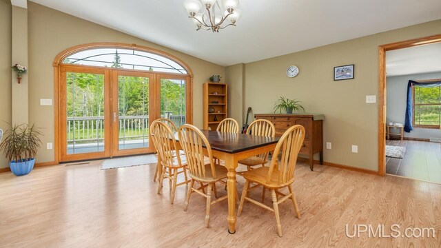 W5716 Warner Ln, Norway, MI 49870 - dining area with a chandelier, light wood finished floors, vaulted ceiling, and baseboards