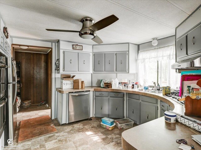 7150 Denissen St, Lexington, MI 48450 - kitchen featuring stainless steel dishwasher, gray cabinets, a ceiling fan, under cabinet range hood, and a textured ceiling