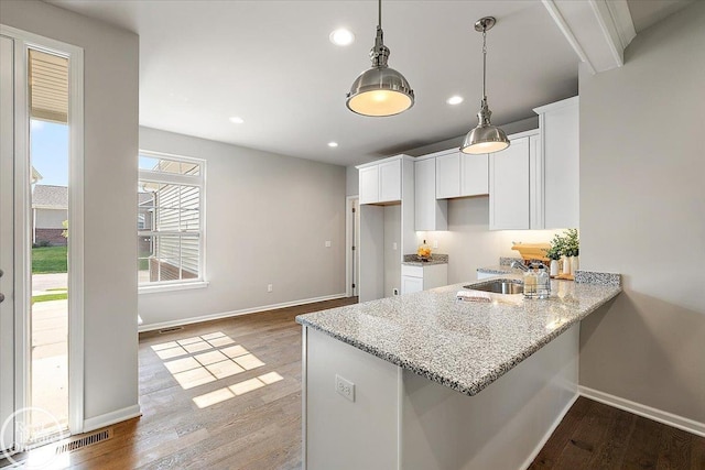 3091 Bridgewater Rd Unit # 28, Auburn Hills, MI 48326 - kitchen with white cabinetry, recessed lighting, light stone countertops, baseboards, and wood finished floors