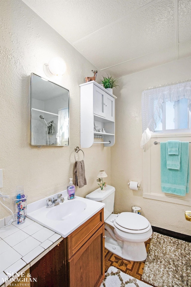 1317 Oak St, Port Huron, MI 48060 - bathroom featuring toilet, vanity, a shower, a textured wall, and a textured ceiling
