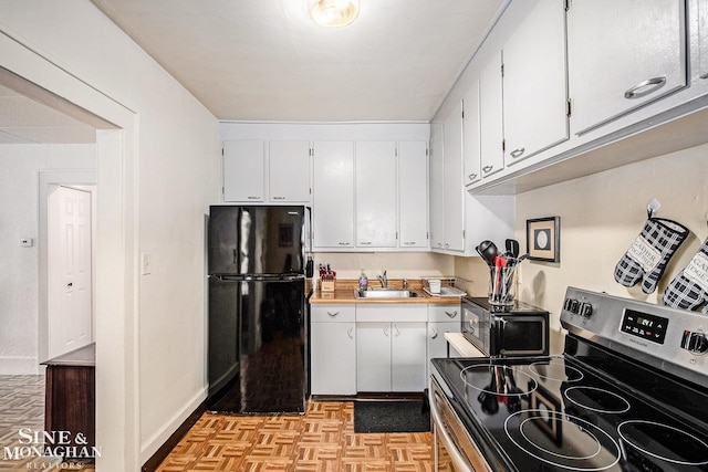 1317 Oak St, Port Huron, MI 48060 - kitchen featuring black appliances, white cabinets, and light countertops