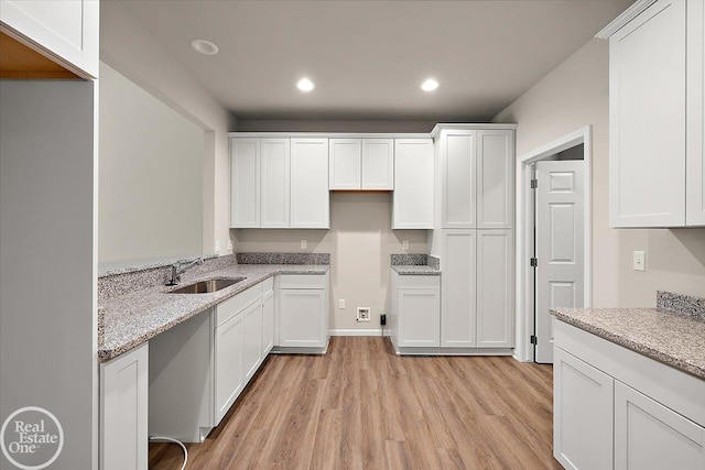3095 Bridgewater Rd Unit # 30, Auburn Hills, MI 48326 - kitchen featuring a sink, light wood-style floors, white cabinets, light stone counters, and recessed lighting