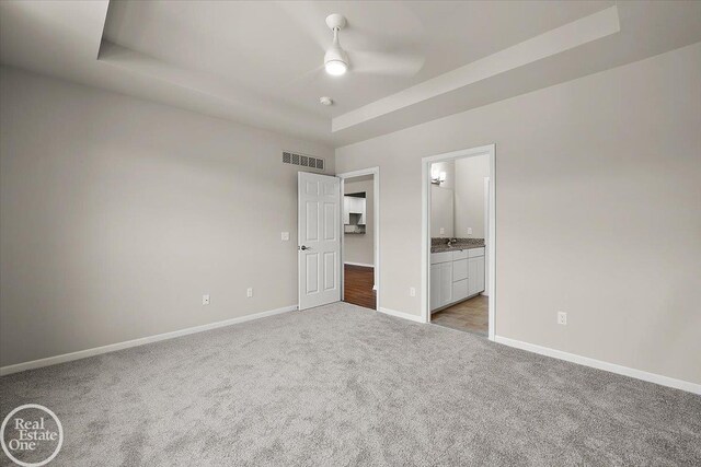 3095 Bridgewater Rd Unit # 30, Auburn Hills, MI 48326 - unfurnished bedroom with baseboards, light colored carpet, and a tray ceiling
