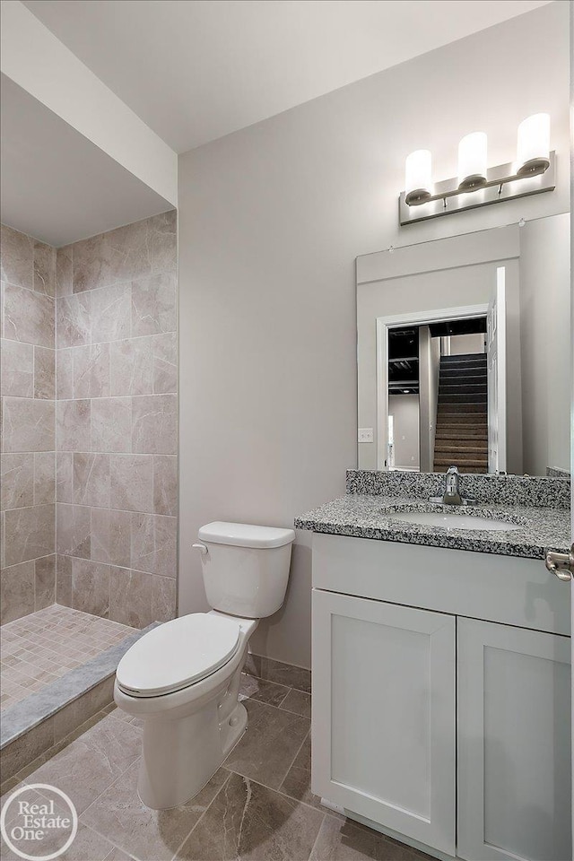 3095 Bridgewater Rd Unit # 30, Auburn Hills, MI 48326 - bathroom featuring toilet, vanity, a tile shower, and baseboards
