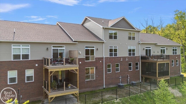 3095 Bridgewater Rd Unit # 30, Auburn Hills, MI 48326 - rear view of property featuring a fenced backyard, brick siding, a balcony, and a sunroom