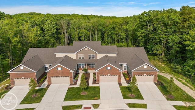 3095 Bridgewater Rd Unit # 30, Auburn Hills, MI 48326 - view of front of house featuring a forest view, concrete driveway, a front yard, and a garage