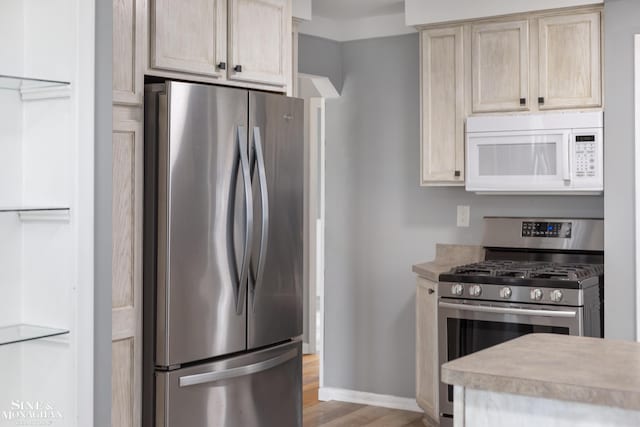 23016 California St, Saint Clair Shores, MI 48080 - kitchen featuring appliances with stainless steel finishes, light wood-type flooring, light countertops, and baseboards