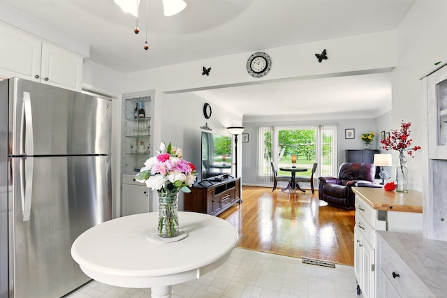 14810 28 Mile Rd, Washington, MI 48094 - kitchen featuring freestanding refrigerator, white cabinets, and open floor plan