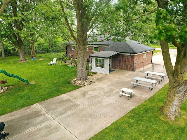 14810 28 Mile Rd, Washington, MI 48094 - rear view of house with a playground, brick siding, a patio, and driveway