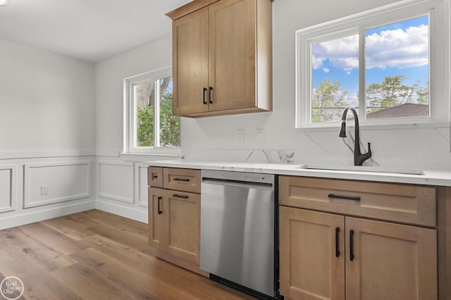 24665 Greenbrier Ave, Eastpointe, MI 48021 - kitchen with stainless steel dishwasher, a sink, light wood-type flooring, light countertops, and a wainscoted wall