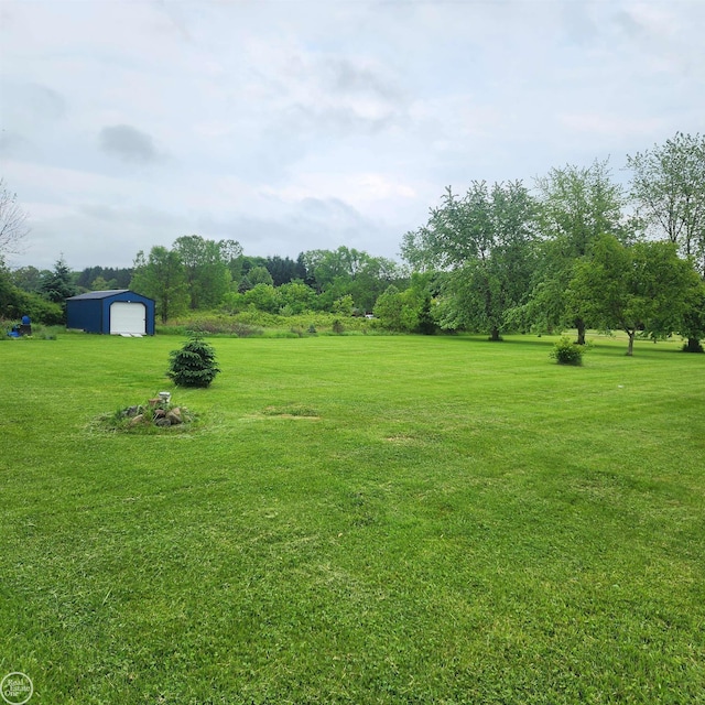 76540 Andrews Rd, Richmond, MI 48062 - view of grassy yard featuring an outbuilding and a detached garage