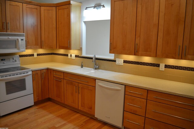 2423 Birchcrest Ct, Sterling Heights, MI 48314 - kitchen featuring white appliances, a sink, light wood finished floors, backsplash, and light countertops