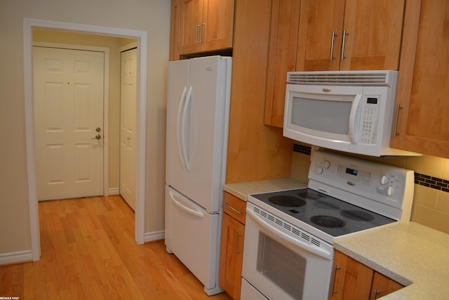 2423 Birchcrest Ct, Sterling Heights, MI 48314 - kitchen featuring white appliances, light wood-type flooring, light countertops, and backsplash
