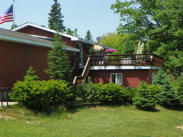 489 Broad St, Harrison, MI 48625 - rear view of house featuring a lawn, a deck, and stairs