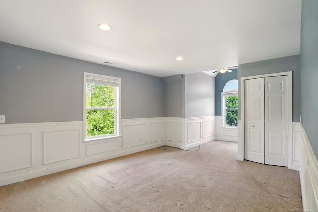 7859 Pine Ridge Dr, Clarkston, MI 48346 - unfurnished bedroom with multiple windows, carpet flooring, wainscoting, recessed lighting, and a closet