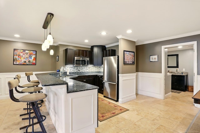 7859 Pine Ridge Dr, Clarkston, MI 48346 - kitchen with appliances with stainless steel finishes, a sink, a kitchen bar, dark stone countertops, and a peninsula