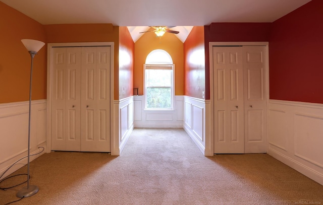 7859 Pine Ridge Dr, Clarkston, MI 48346 - unfurnished bedroom with light carpet, wainscoting, two closets, a decorative wall, and a ceiling fan
