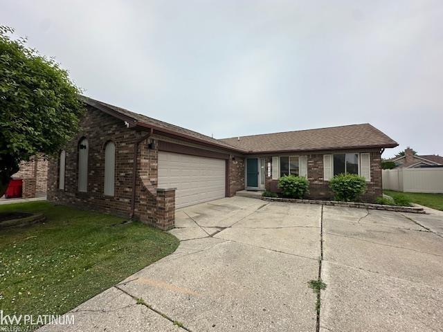 16754 Sarno Dr, Macomb, MI 48044 - single story home with a garage, brick siding, and concrete driveway