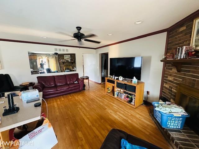 16754 Sarno Dr, Macomb, MI 48044 - living area featuring crown molding, a ceiling fan, a brick fireplace, wood finished floors, and recessed lighting