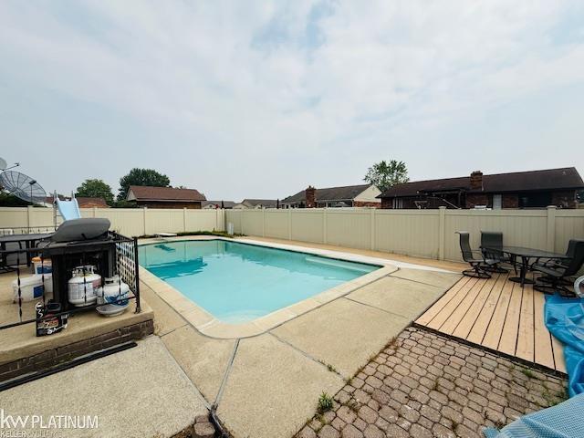 16754 Sarno Dr, Macomb, MI 48044 - view of pool with a fenced backyard, outdoor dining space, a patio area, and a wooden deck