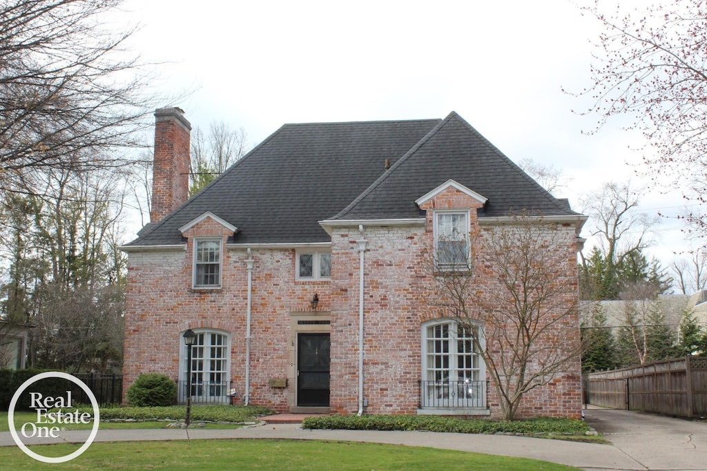 93 Moran Rd, Grosse Pointe Farms, MI 48236 - rear view of house with a chimney, brick siding, and roof with shingles