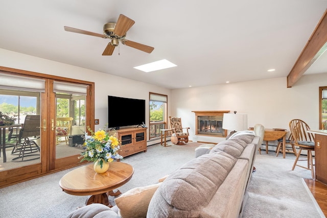 220 Lakeview St, Beaverton, MI 48612 - carpeted living area featuring baseboard heating, plenty of natural light, a ceiling fan, a glass covered fireplace, and recessed lighting