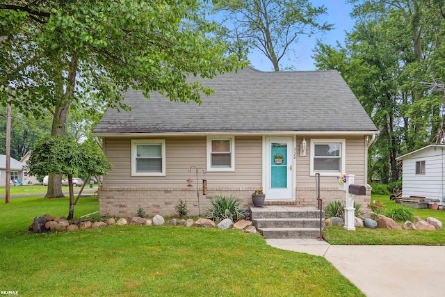 724 Columbia St, Algonac, MI 48001 - view of front of house with brick siding, a front yard, and roof with shingles