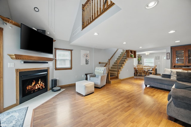 724 Columbia St, Algonac, MI 48001 - living room with stairs, light wood-style floors, a fireplace with flush hearth, recessed lighting, and baseboards