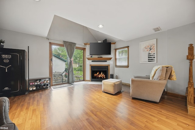 724 Columbia St, Algonac, MI 48001 - living area with lofted ceiling, light wood-style floors, a lit fireplace, baseboards, and recessed lighting