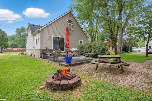 724 Columbia St, Algonac, MI 48001 - rear view of house featuring a fire pit, a patio area, a yard, and a playground