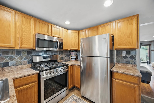 724 Columbia St, Algonac, MI 48001 - kitchen with appliances with stainless steel finishes, tasteful backsplash, light stone counters, and recessed lighting