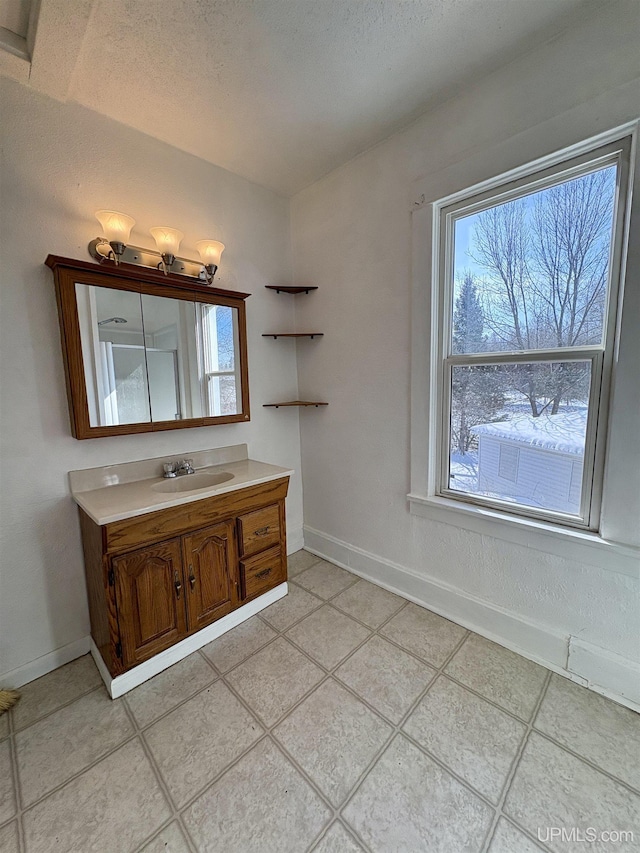 909 Sutherland Ave, Ironwood, MI 49938 - bathroom with vanity, baseboards, tile patterned flooring, and a textured ceiling