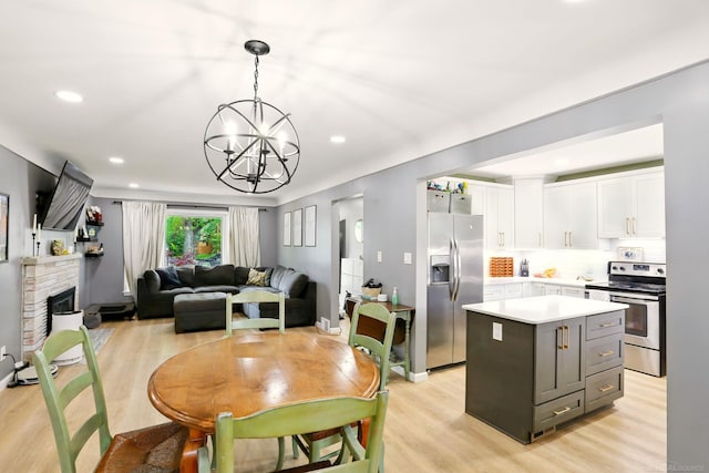 21629 Yale St, Saint Clair Shores, MI 48081 - dining area with a chandelier, light wood-style floors, recessed lighting, and a fireplace