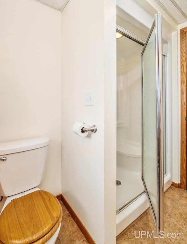 2119 S 21st Ave, Escanaba, MI 49829 - bathroom with a shower stall, baseboards, and toilet