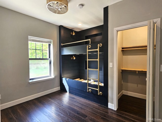 48050 Harma Rd, Atlantic Mine, MI 49905 - unfurnished bedroom with baseboards, dark wood-type flooring, and a walk in closet