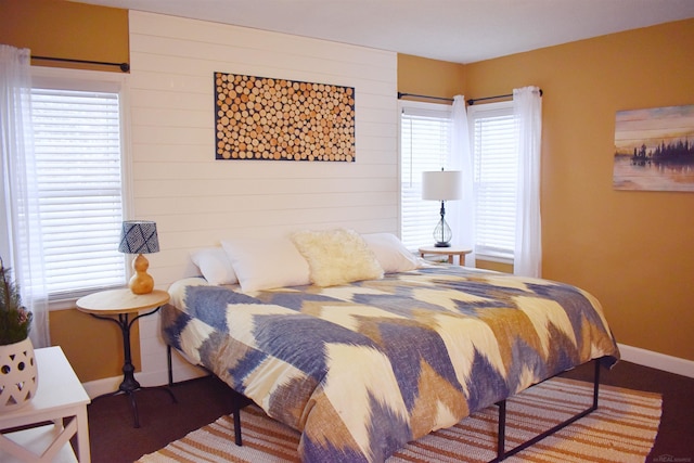 110 W Francis St, Ironwood, MI 49938 - bedroom with baseboards, multiple windows, and wood walls