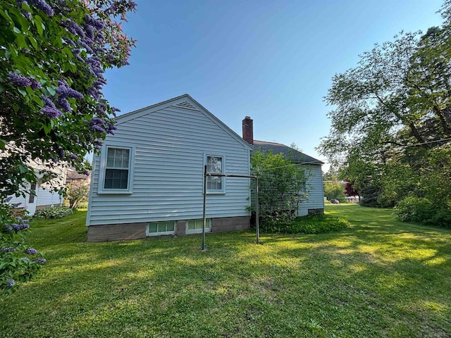 110 W Francis St, Ironwood, MI 49938 - view of side of home with a lawn and a chimney