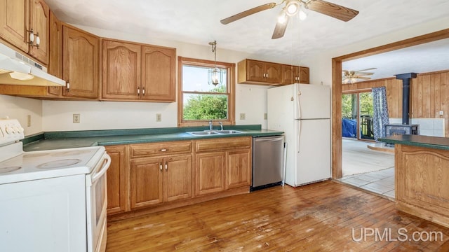 8102 W.5 Rd, Rapid River, MI 49878 - kitchen with white appliances, a wood stove, a sink, under cabinet range hood, and ceiling fan