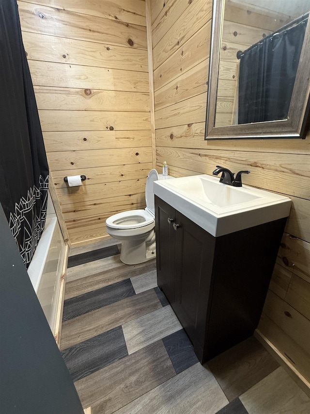 240 Lumm St, Gladwin, MI 48624 - bathroom with vanity, toilet, wood walls, wood finished floors, and shower / tub combo