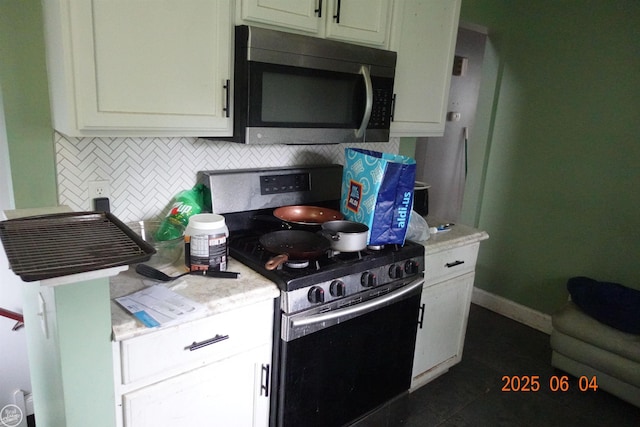1321 Cornell Rd, Muskegon, MI 49441 - kitchen featuring appliances with stainless steel finishes, tasteful backsplash, light countertops, and white cabinetry