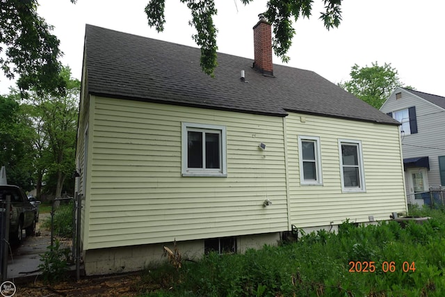 1321 Cornell Rd, Muskegon, MI 49441 - rear view of property featuring roof with shingles and a chimney