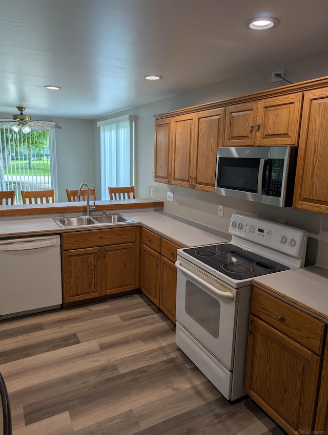 60606 Avendt Dr, New Haven, MI 48048 - kitchen with white appliances, a sink, brown cabinetry, light countertops, and recessed lighting
