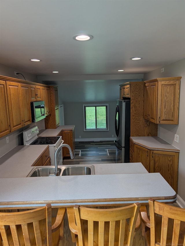 60606 Avendt Dr, New Haven, MI 48048 - kitchen with appliances with stainless steel finishes, a sink, light countertops, brown cabinetry, and recessed lighting