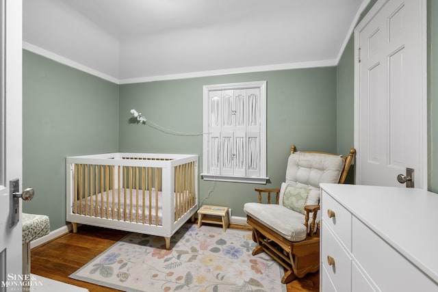 1984 Lancaster St, Grosse Pointe Woods, MI 48236 - bedroom featuring a nursery area, wood finished floors, and baseboards